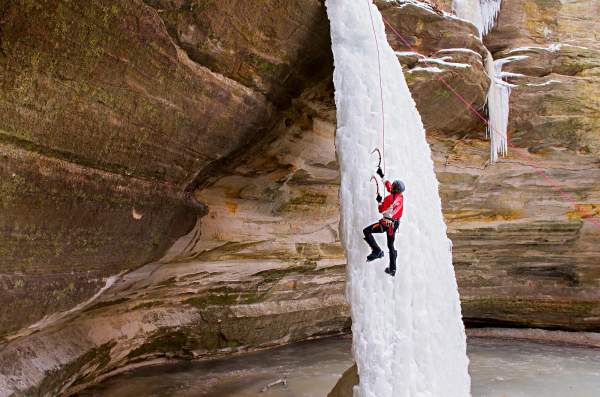 Persona escalando una cascada de hielo