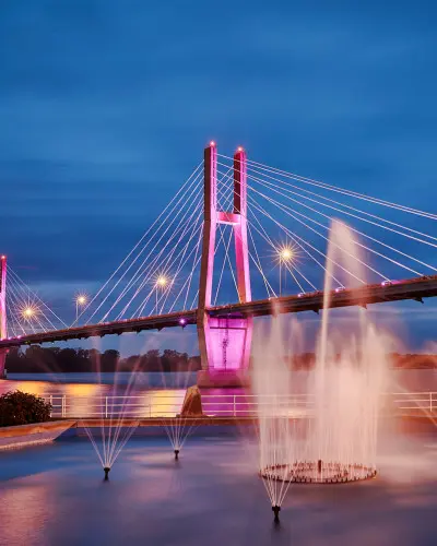 Un puente iluminado con fuentes de agua