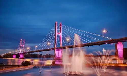 Un puente iluminado con fuentes de agua