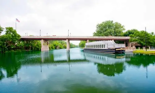 Barco sobre el agua con un puente al fondo