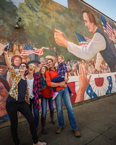 Familia tomándose un selfie delante de un mural en Ottawa