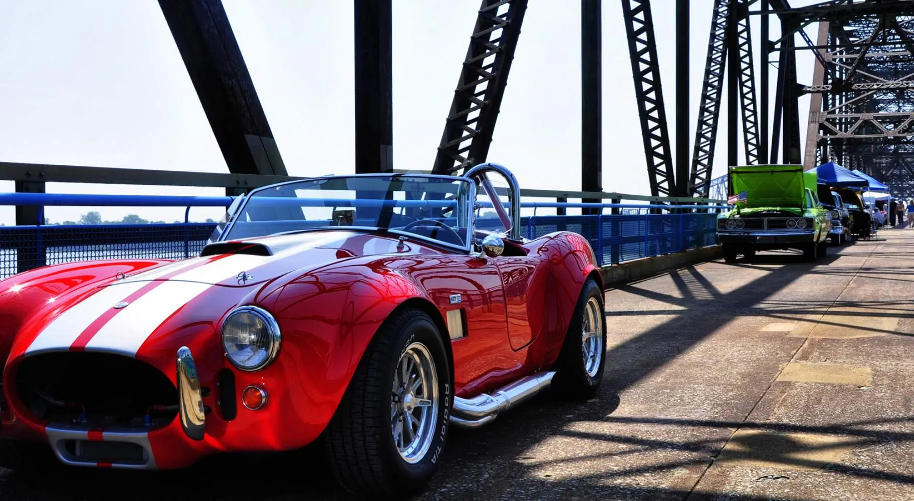 Un coche rojo de época aparcado a lo largo de la cadena de rocas puente
