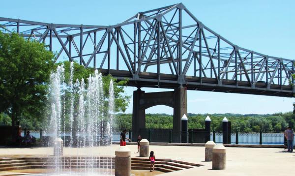 Una fuente frente a un puente que cruza el río Illinois en Peoria