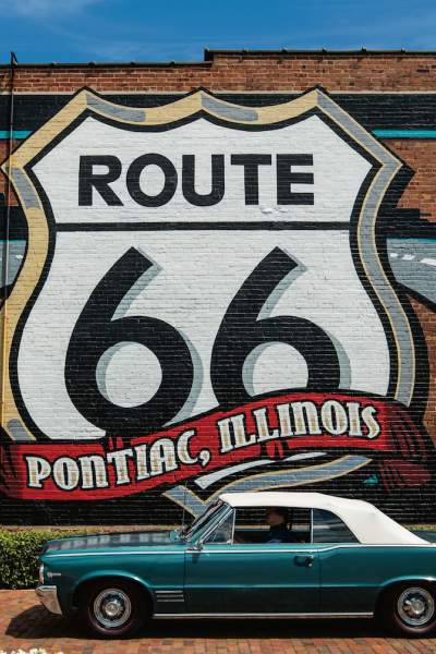 Mural de la Ruta 66 con un coche Pontiac delante.