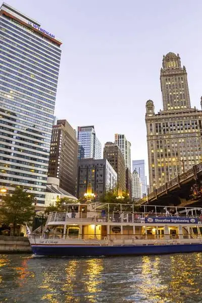 Un barco en el agua con los grandes edificios de la ciudad detrás