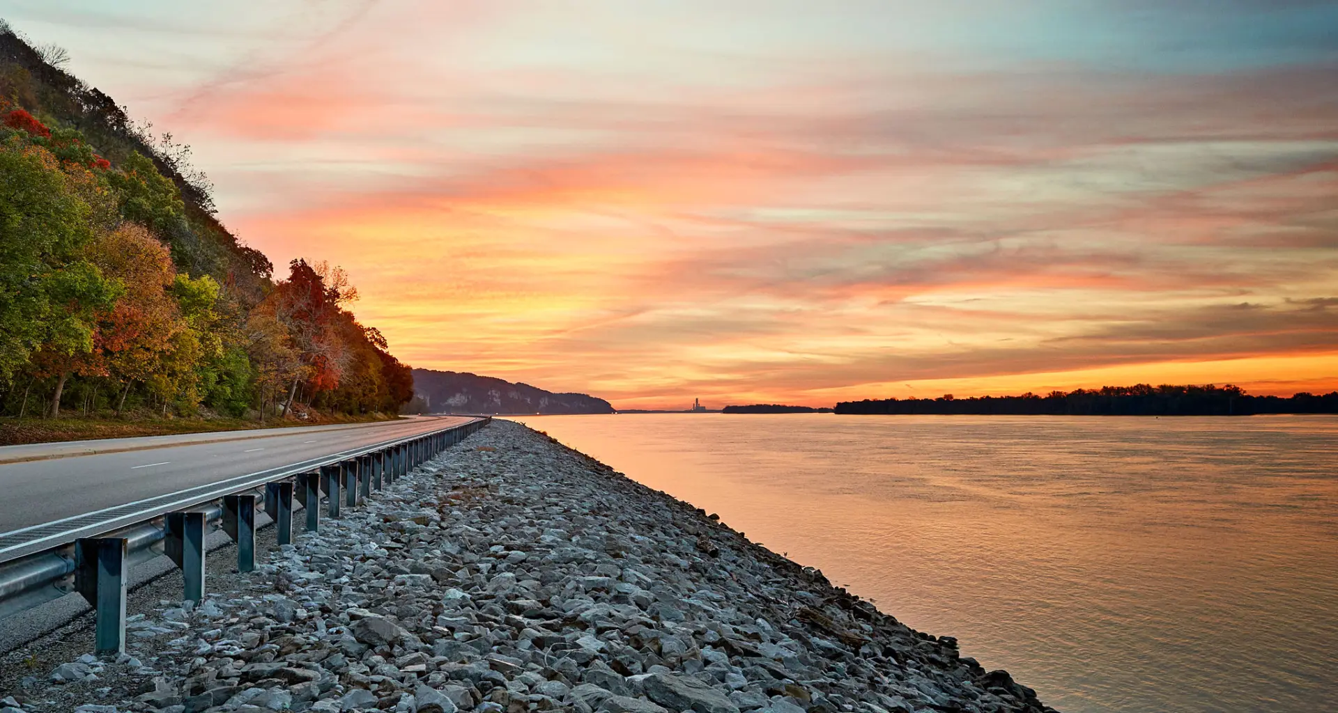 Puesta de sol sobre el agua y un camino junto al río