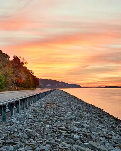 Puesta de sol sobre el agua y un camino junto al río