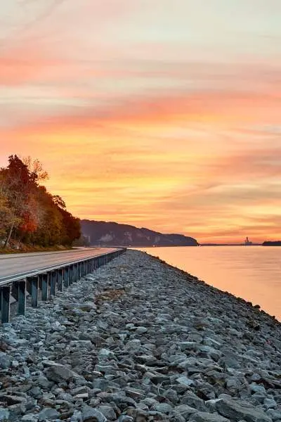 Puesta de sol sobre el agua y un camino junto al río