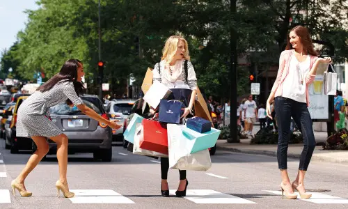 Mujeres cruzando la calle con bolsas de la compra