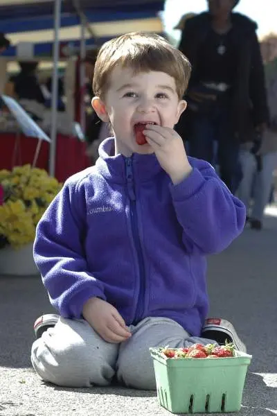 Un niño come fresas en un mercado de Illinois