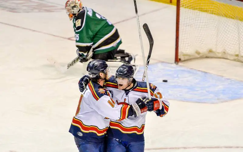Dos jugadores de hockey celebran un gol sobre el hielo