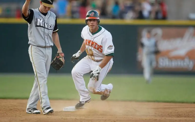 Un jugador de béisbol corriendo por el diamante pasa una base