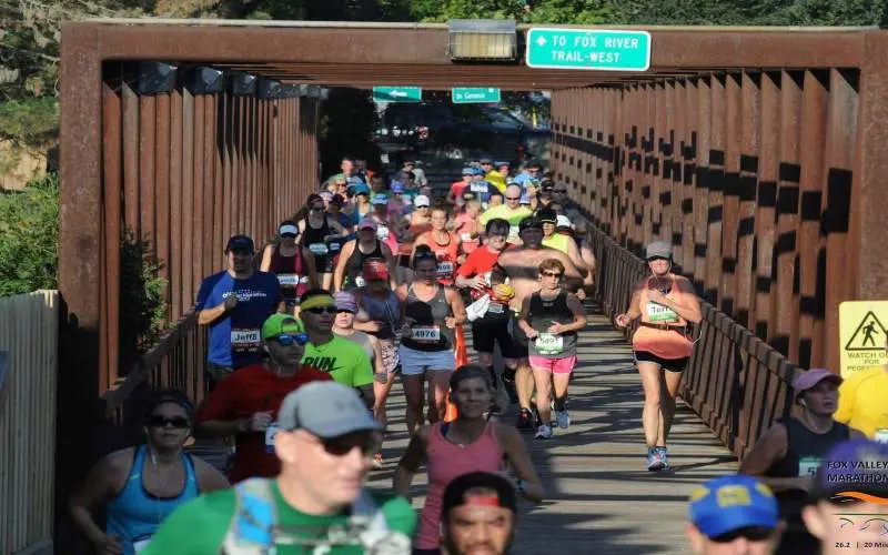 Gente corriendo sobre un puente cubierto en un maratón