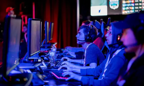 Personas en ordenadores compitiendo en un torneo de esports