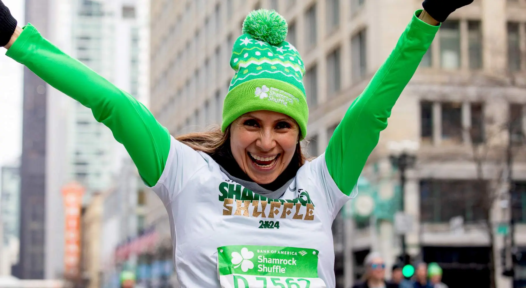Una corredora vestida de verde con los brazos en alto
