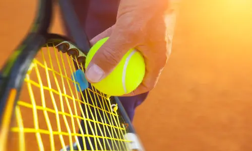 Primer plano de alguien preparándose para servir una pelota de tenis