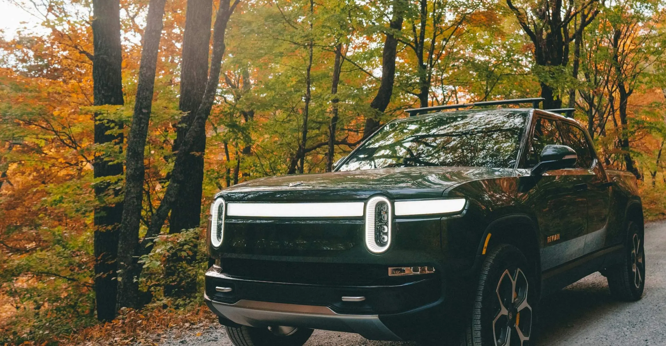 Vehículo eléctrico Rivian circulando por un camino de grava