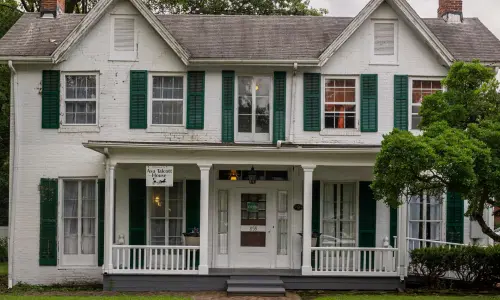 Vista frontal de una casa histórica y un sitio del ferrocarril subterráneo.